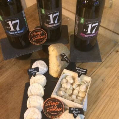 Une table avec plusieurs fromages et 3 bouteilles de vin chez Le Temps d'un Fromage à Cognac